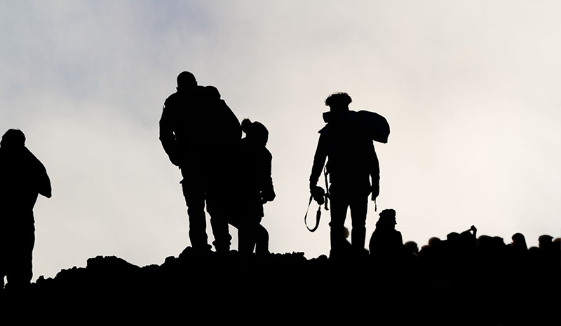 Silhouettes of men on the volcano Etna